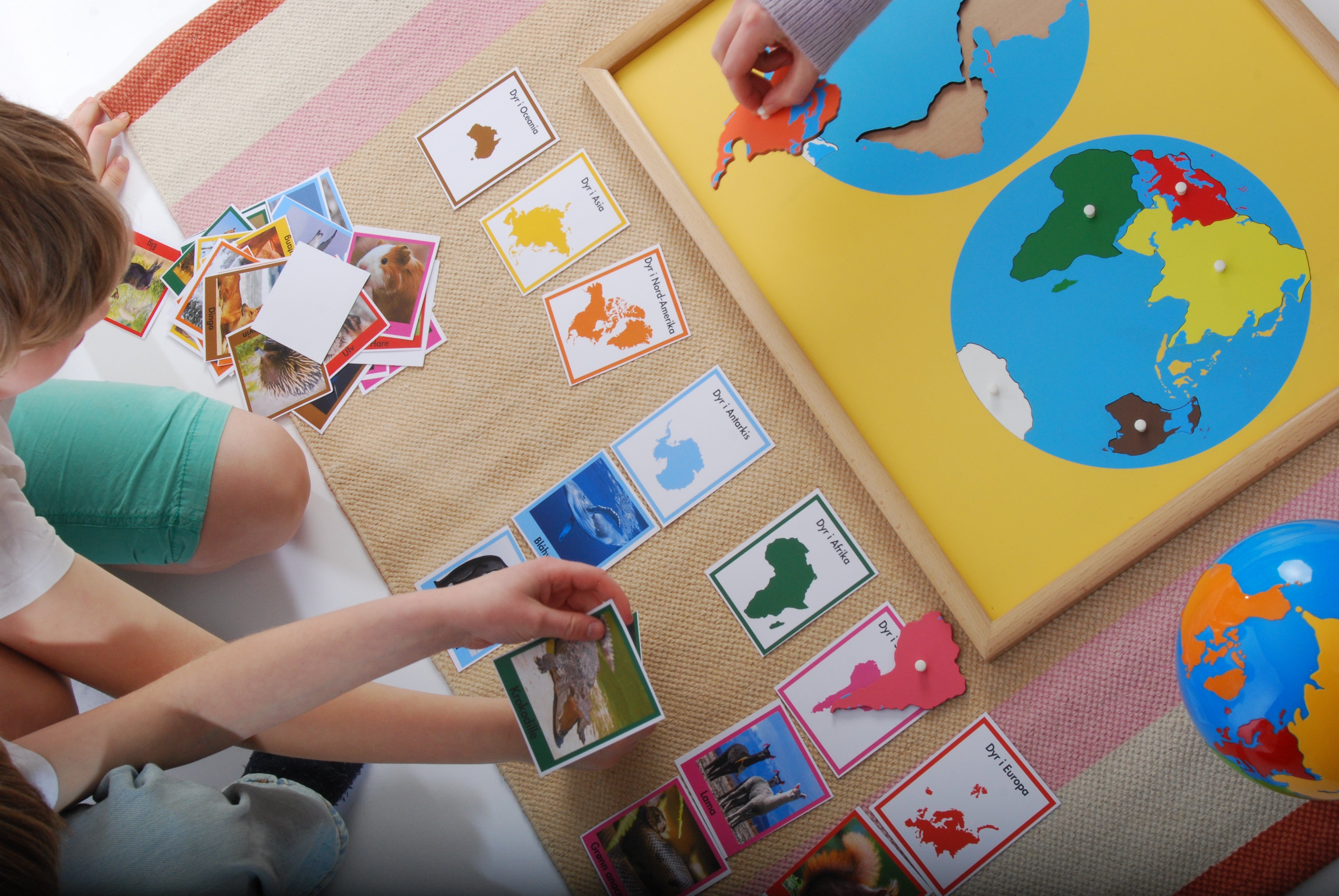 Barn som lærer om geografi med Montessori verdenskart