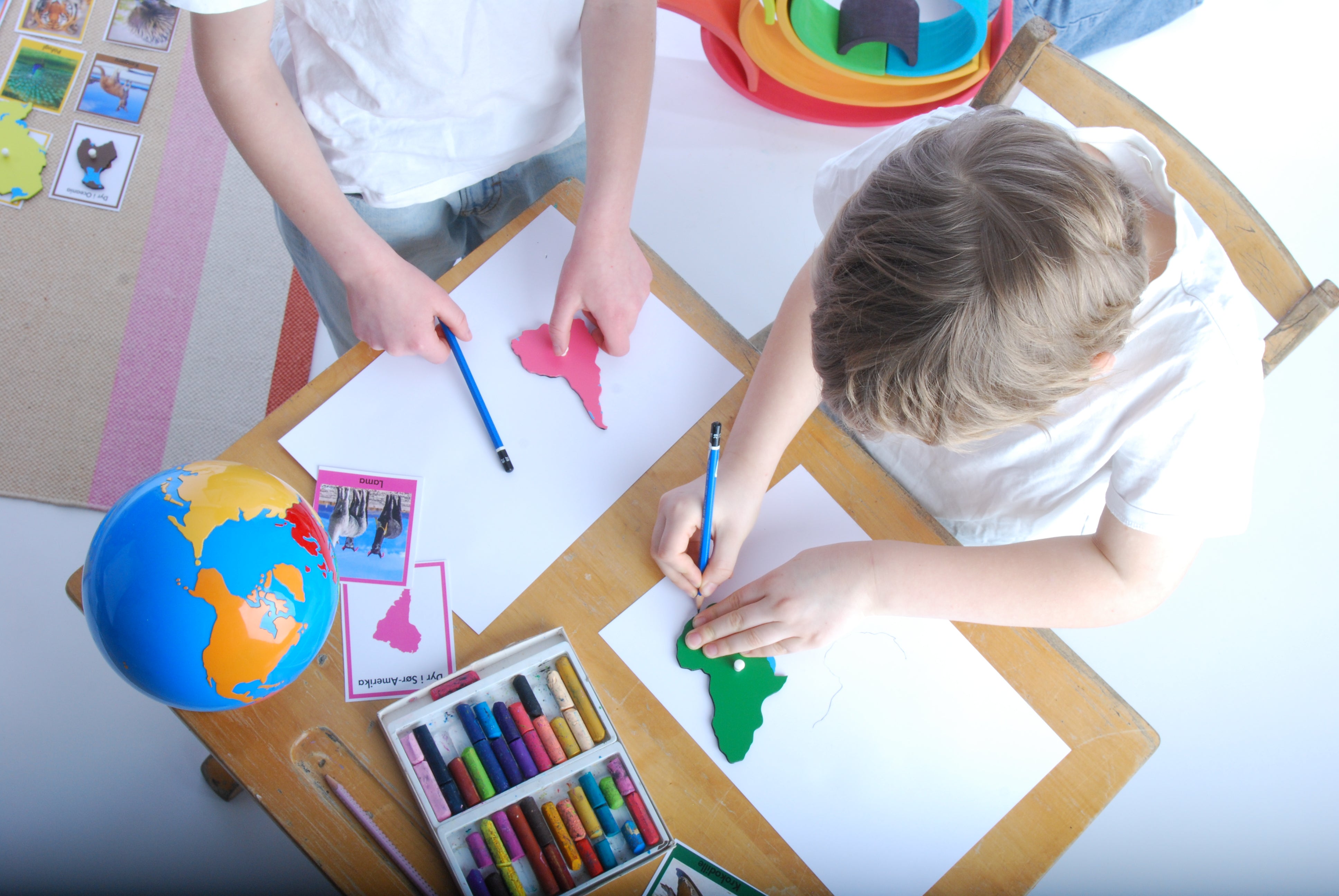 Barn som tegner kontinentene med Montessori puslespill