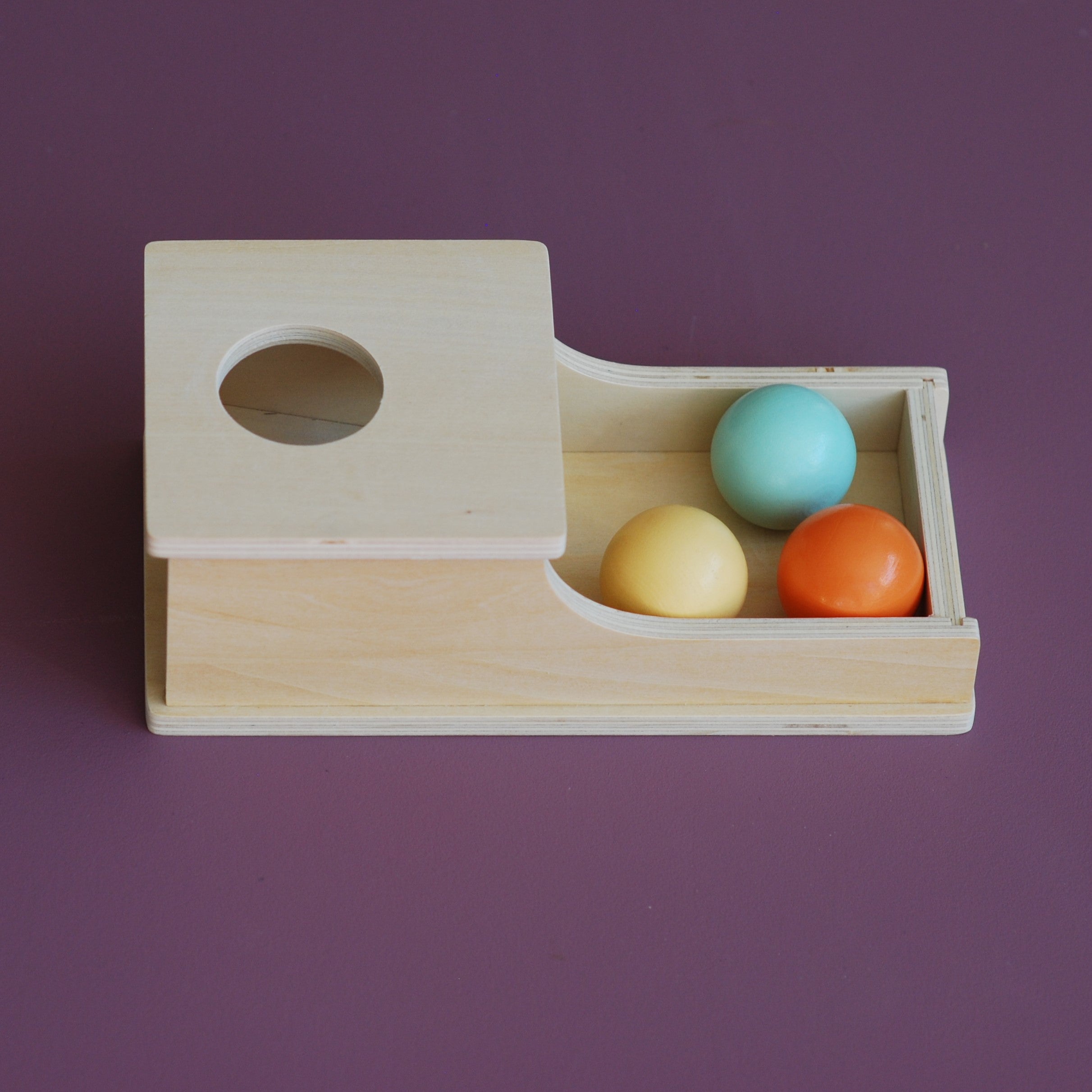 Montessori putteboks av tre med fargerike baller